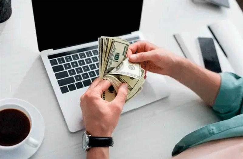 Pessoa trabalhando com vendas online e renda digital em dólar no computador.